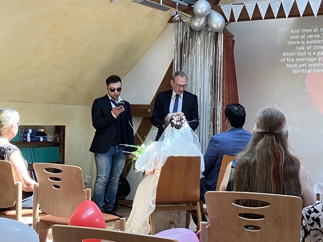 The bride and groom sitting for the wedding service - German